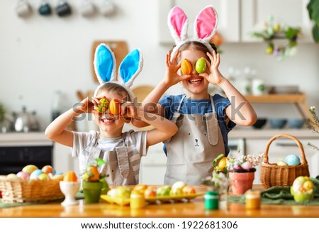 Happy easter!   funny children boy and girl with ears hare playing, getting ready for holiday and painting eggs
