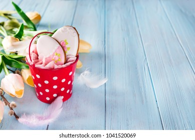 Happy Easter gingerbread cookie eggs with bucket on blue wood background,