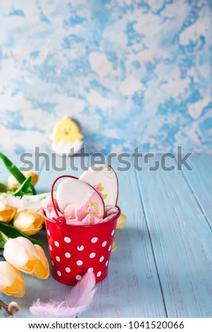 Happy Easter gingerbread cookie eggs with bucket on blue wood background,