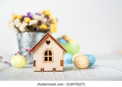 Happy Easter greeting card. Miniature wooden house. Rabbits, colorful eggs, spring flowers with tag for text.. - Shutterstock ID 2134733271