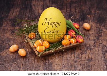 Happy Easter: Inscribed Easter egg with the inscription Happy Easter on a wooden background with flowers.