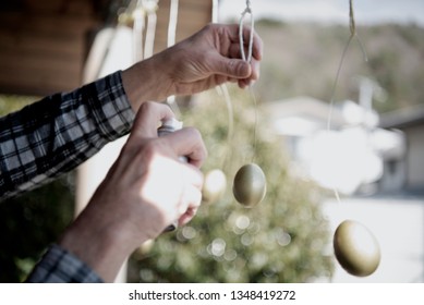 Happy Easter- Soft focus egg being spray painted, man spray painting Easter egg