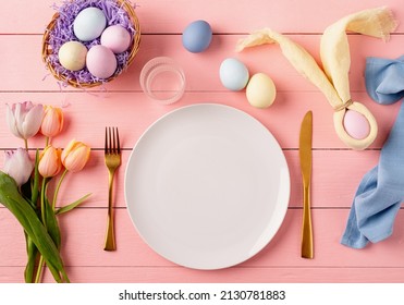 Happy Easter. Table Setting For Easter Feast. Easter Eggs, Bunny, Tulips And Cutlery Top View Flat Lay On Pink Rustic Background