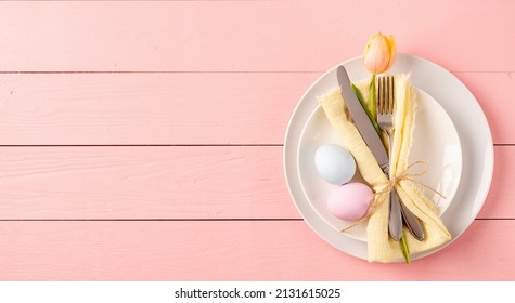 Happy Easter. Table setting for Easter feast. Easter eggs, tulips and cutlery top view flat lay on pink rustic background - Powered by Shutterstock