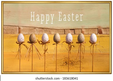 Happy easter text with marbled eggs on sticks and painted background golden frame