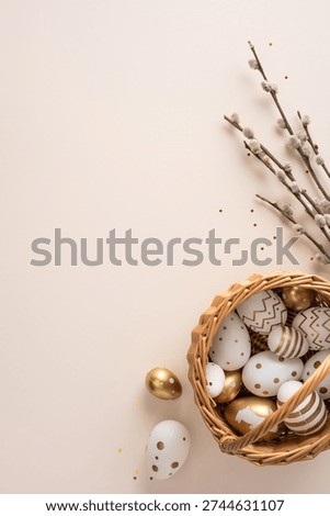 Happy Easter vertical greeting concept with gold and white painted eggs arranged in a wicker basket beside pussywillow branches for elegant spring celebration