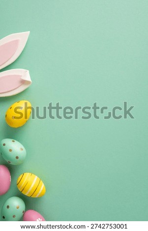 Happy Easter vertical greeting featuring pastel painted eggs, decorative bunny ears and space for a message on a mint background