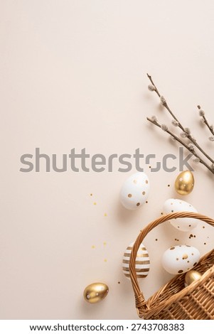Happy Easter vertical greeting featuring a gold polka dot egg and striped egg spilling from a wicker basket beside a pussywillow branch on a soft beige background for spring celebration