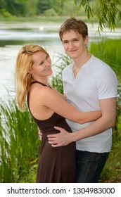 Happy Eastern European Couple In Love Embracing By The Shore Of A Lake Toronto, Ontario, Canada - June 25, 2011 With Model Releases