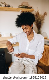 Happy E-commerce Business Owner Checking Customer Reviews On Phone. Jewelry Designer Woman Checking Jewelry Designs On Phone In Studio.