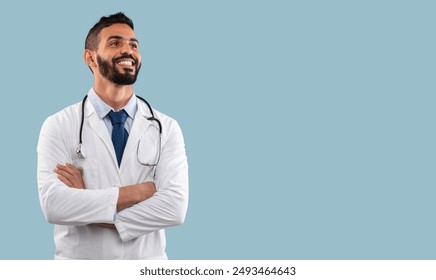 Happy Egyptian Physician Man Smiling Looking Aside Posing With Stethoscope Near Copy Space Standing In Studio Over Blue Background. Doctor's Portrait. Medical Career Concept - Powered by Shutterstock