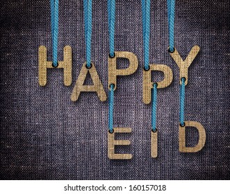 Happy Eid letters hanging strings with blue sackcloth background.