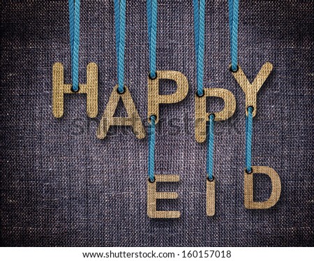 Happy Eid letters hanging strings with blue sackcloth background.