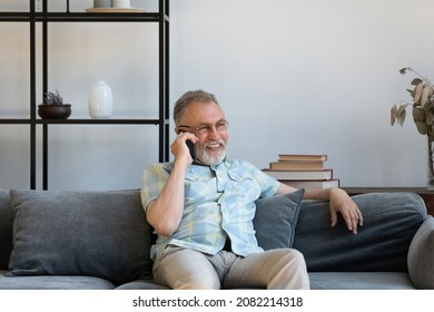 Happy elder grandfather talking on mobile phone, resting on comfortable sofa, speaking, smiling, laughing, chatting, contact family. Senior grey haired man making telephone call from home - Powered by Shutterstock