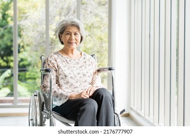 Happy Elderly Adult Retired Asian Woman Sit On Wheelchair At Home. Smiling Asian Senior Old Grandma Sit On Wheelchair At Hospital