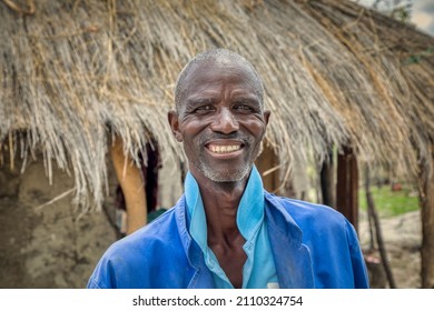 Happy Elderly African Man Portrait, In Front Of His House In An African Village