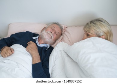 Happy Elderly Couple Caucasian Senior Man Snoring And Woman Sleeping Together In White Blanket In Bedroom, Retirement Love Lifestyle Concept