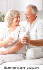 Happy Elderly Couple Drinking Milk At Home