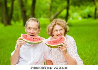 Happy Elderly Couple Eating Watermelon Outdoors