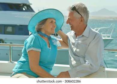 Happy Elderly Couple Have A Ride In A Boat On Sea