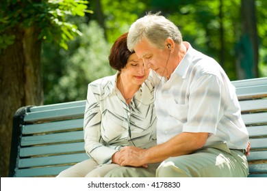 Happy Elderly Couple Listening Music In Headset Or Praying Together, Outdoors