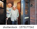 Happy Elderly Couple Opening the Front Door