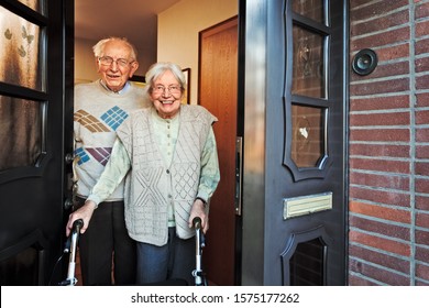 Happy Elderly Couple Opening The Front Door