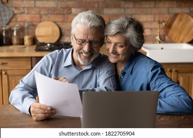 Happy elderly couple read postal paper document satisfied with banking health insurance contract or notice. Smiling mature man and woman consider good news in post paperwork letter correspondence.