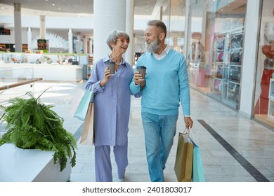 Happy elderly couple in shopping mall going for Black Friday sales - Powered by Shutterstock