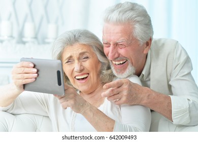 Happy elderly couple with a tablet computer