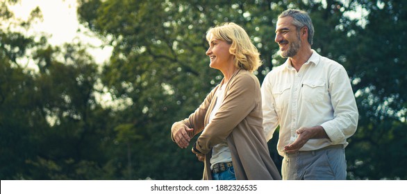 Happy Elderly Dancing Together At Outdoor In The Park With Warming Sunlight Atmosphere, Worry Free For Retirement Senior People, Lovely Older Lifestyle Healthy And Happiness. Old Age Healthy Couple.