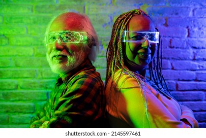 Happy Elderly Friends Having Fun With Futuristic Augmented Reality Glasses, Multiracial Couple Asian Male And Hispanic American Female - Metaverse Concept