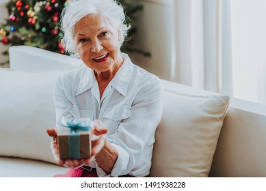 Happy Elderly Lady Holding Gift Box Stock Photo