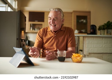 Happy Elderly Man Drinking Coffee And Video Calling Friend Or Family Member