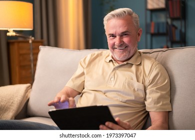 Happy Elderly Man Learning How The Internet Works. Proud Older Man Sitting With A Tablet. Relaxed Senior Man Reading Articles On The Internet. Mature Man Laughing At Jokes, Memes Seen On The Internet