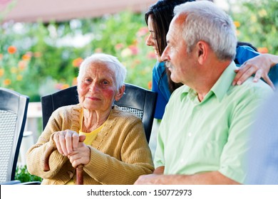 Happy Elderly Patient With Doctor And Visitor.