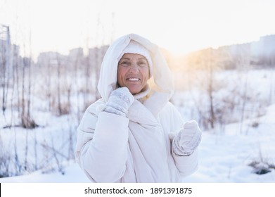 Happy Elderly Senior Mature Woman In White Warm Outwear Playing With Snow In Sunny Winter Outdoors. Retired Healthy People Holiday Vacation Winter Activities, Active Lifestyle Concept