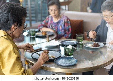 Happy Elderly Senior People Society Family Lifestyle Concept. Ageing Asia Women And Man Having Dinner On Dining Table Together In Hospice Older Wellbeing Nursing Home Community.