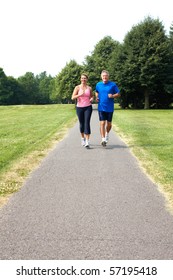 Happy Elderly Seniors Couple Jogging In Park