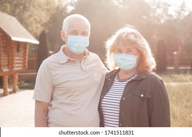 Happy Elderly Seniors Couple Wearing Medical Mask To Protect From Coronavirus In Summer Park, Coronavirus Quarantine