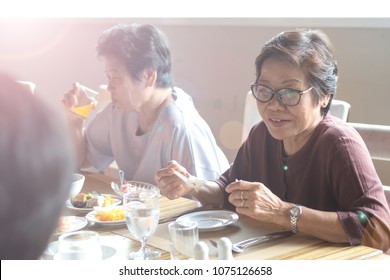 Happy Elderly Twin Senior People Society Lifestyle Concept. Ageing Asia Women Having Dinner On Dining Table Together In Hospice Older Wellbeing Nursing Home Community.