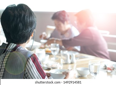 Happy Elderly Twin Senior People Society Lifestyle Concept. Ageing Asia Women Having Dinner On Dining Table Together In Hospice Older Wellbeing Nursing Home Community.