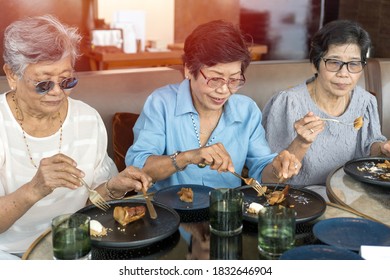 Happy Elderly Twin Senior People Society Lifestyle Concept. Ageing Asia Women Having Dinner On Dining Table Together In Hospice Older Wellbeing Nursing Home Community.