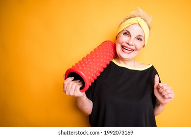Happy elderly woman in black t-shirt holding fascia for exercise smiling and laughing