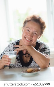 Happy Elderly Woman Eating Lunch And Drinking Milk