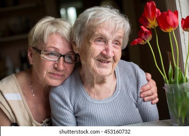 Happy Elderly Woman With Her Daughter In Behind An Embrace.