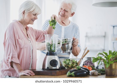 Happy elderly woman and her husband preparing a vegan smoothie - Powered by Shutterstock