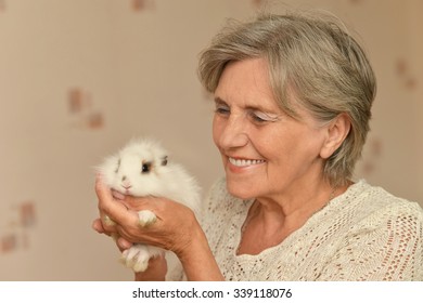 Happy elderly woman with a little rabbit in her arms - Powered by Shutterstock