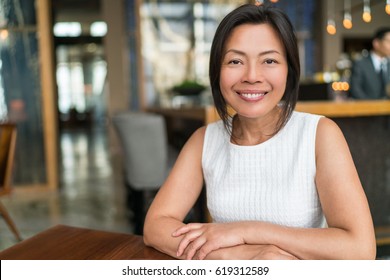 Happy Elegant Asian Middle-aged Businesswoman Smiling Portrait. Beautiful Mature Chinese Business Woman In Fancy Restaurant,