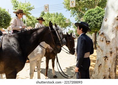 Happy Elegant Ethnic Man And Women Talking During Horse Fair